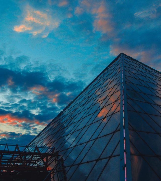 Stunning view of a glass pyramid structure in Viciebsk, Belarus, under a dramatic sunset sky.